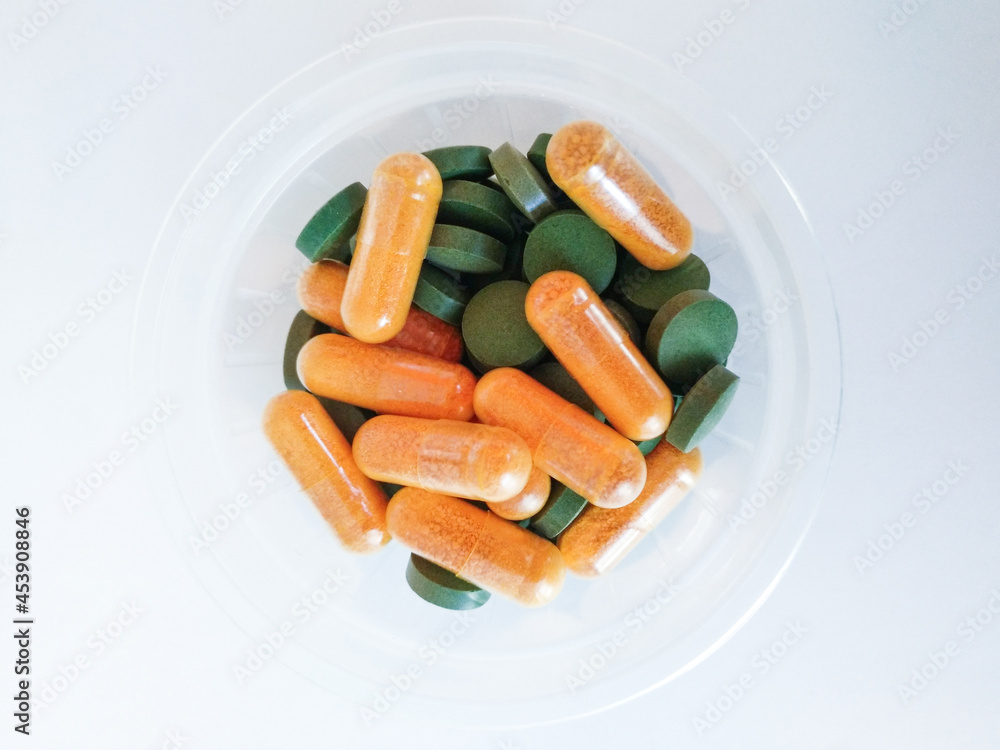 orange and green pills on white background orange and green pills on white background