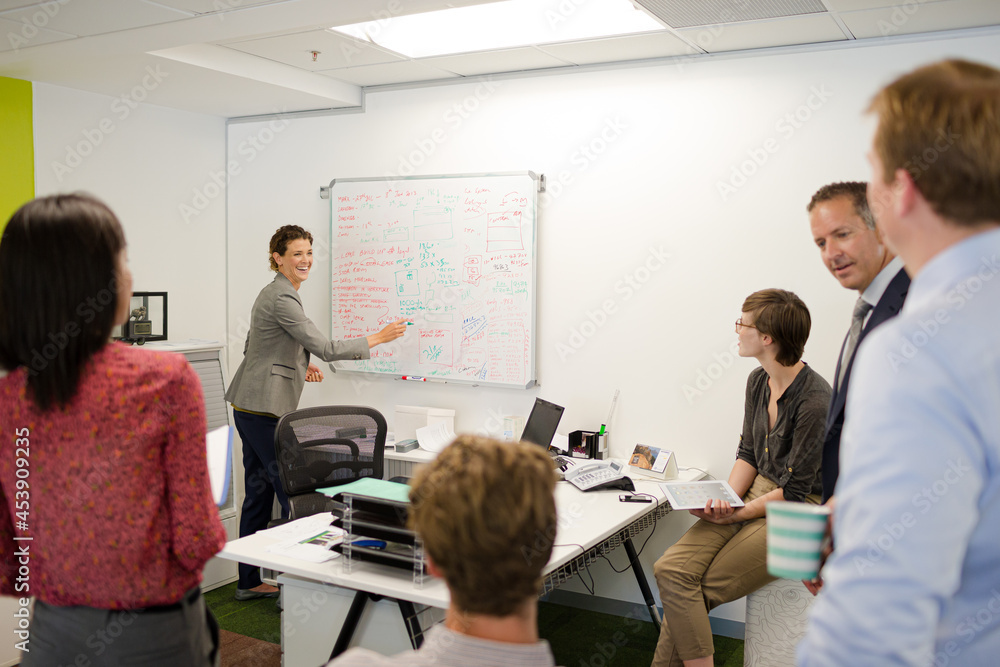 Obraz premium Businesswoman drawing on whiteboard in meeting