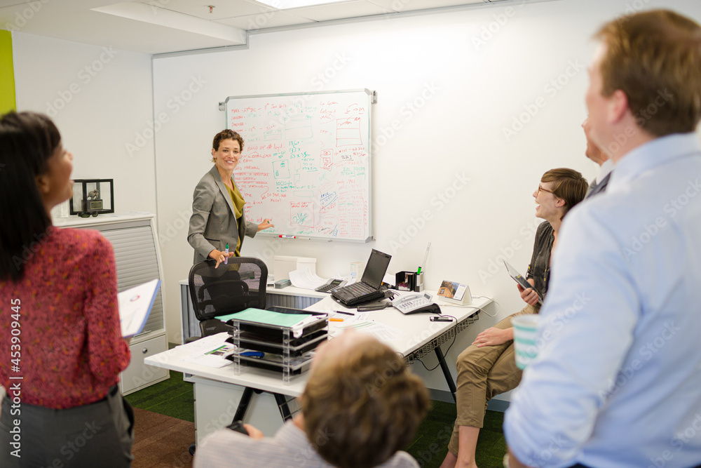 Businesswoman drawing on whiteboard in meeting Businesswoman drawing on whiteboard in meeting