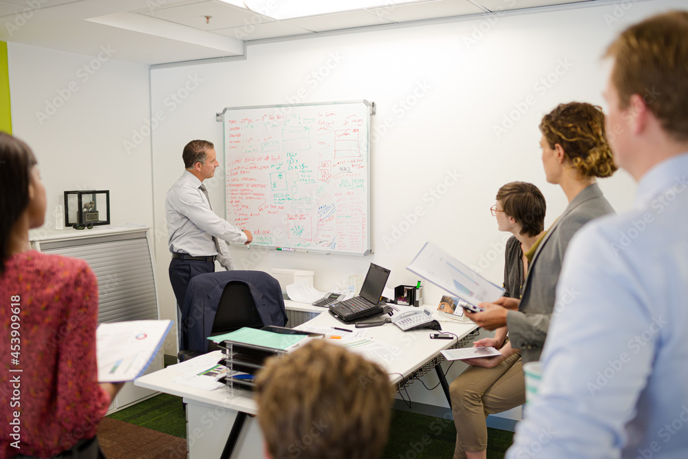Businessman drawing on whiteboard in meeting Businessman drawing on whiteboard in meeting