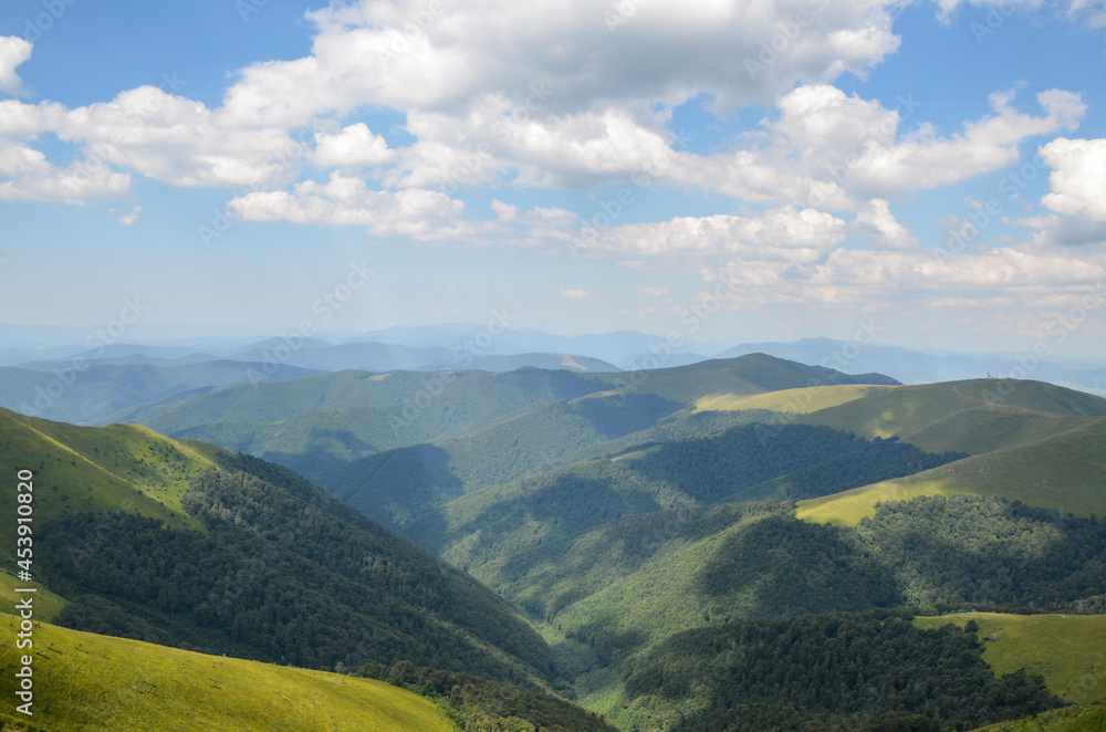 A wonderful summer view of the Carpathian mountain slopes, densely covered with green forest. Borzhava ridge, Transcarpathia, Ukraine
