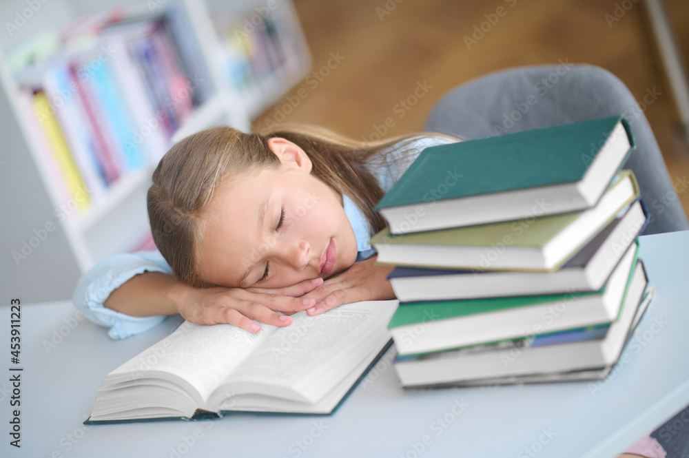 Tired pupil dozing on an open textbook Tired pupil dozing on an open textbook