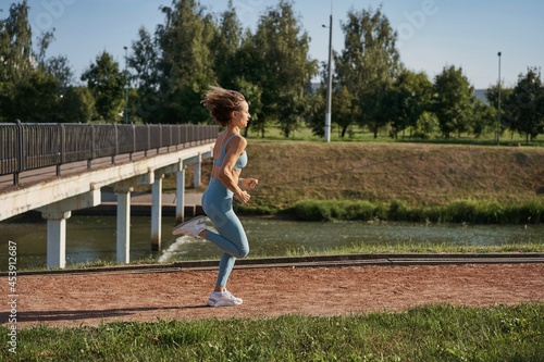Young athletic woman jogging on the road in the morning.