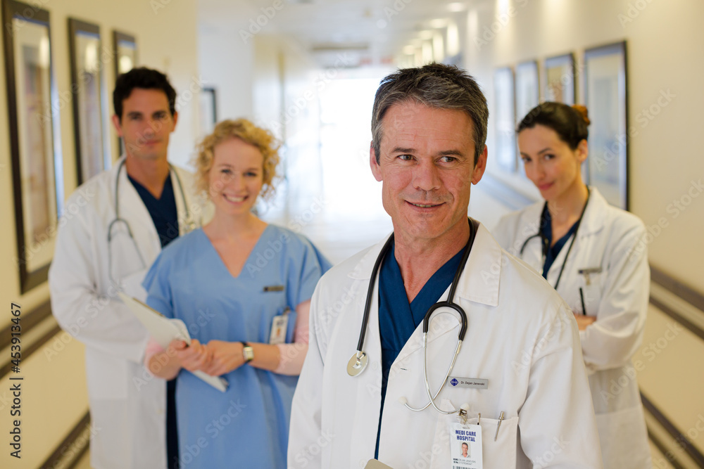 Portrait of smiling doctors and nurse in hospital corridor Portrait of smiling doctors and nurse in hospital corridor