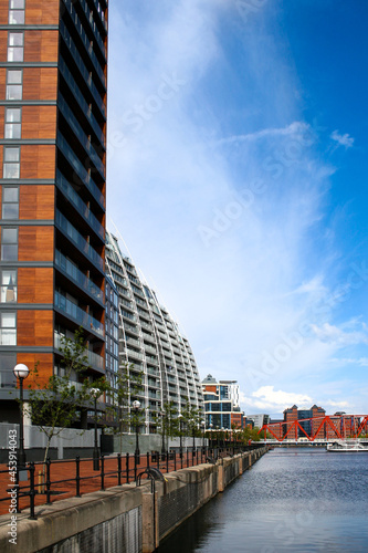 A view of buildings on the water on a sunny day over Salford Quays, Manchester, England. The image has copy space.
