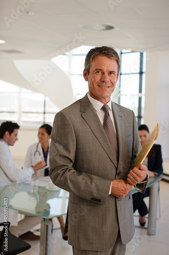Portrait of smiling businessman in meeting with doctors
