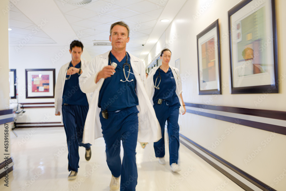 Doctors rushing down hospital corridor Doctors rushing down hospital corridor