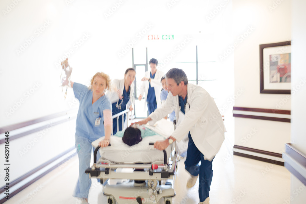 Doctors rushing patient on gurney in hospital corridor Doctors rushing patient on gurney in hospital corridor