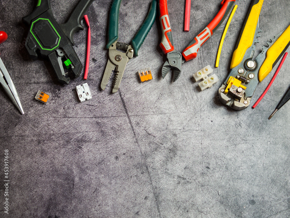 various electrician tools on gray background with copy space. view from above