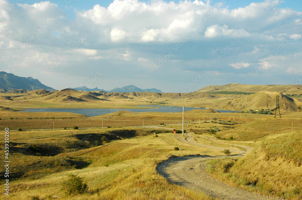 Fototapeta A road among the sandy mountains. The road to Cape Meganom. Crimea.