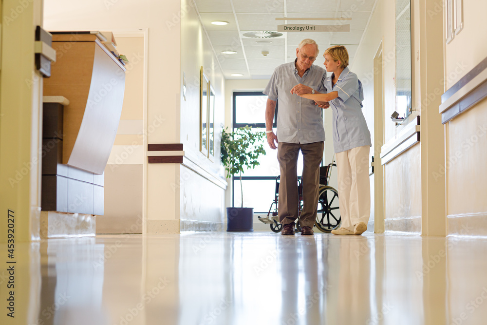 Older patient and nurse standing in hospital