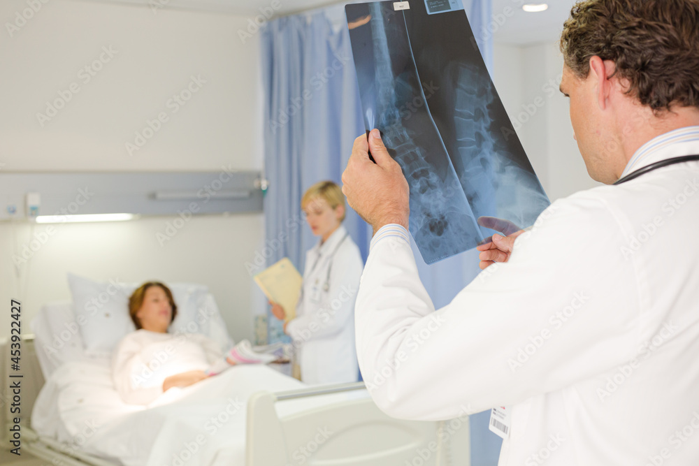 Obraz premium Doctors examining x-rays in hospital room