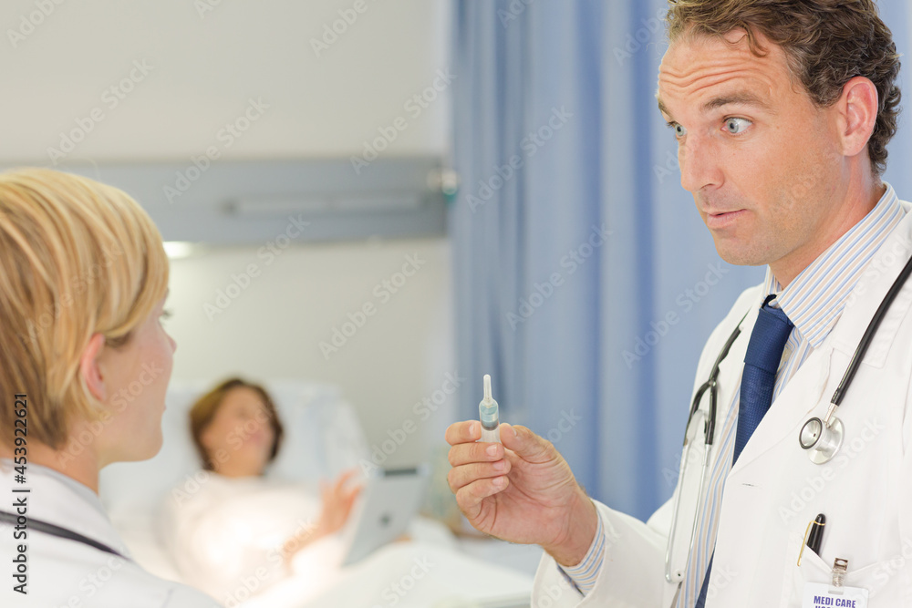 Doctor checking syringe in hospital room Doctor checking syringe in hospital room