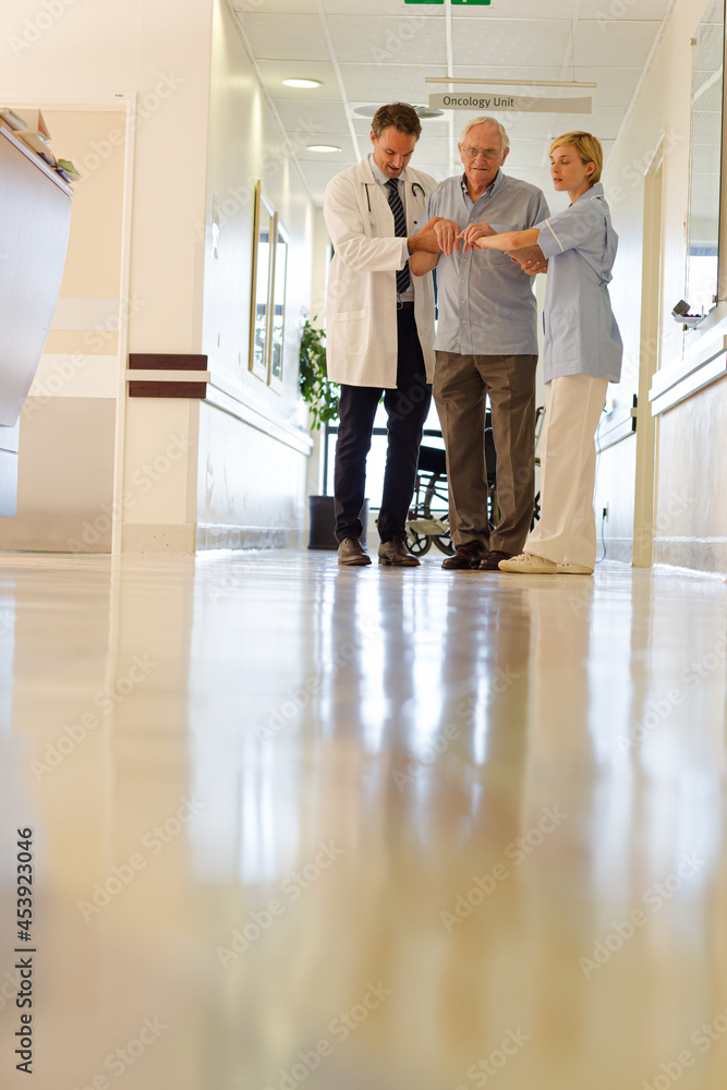 Fototapeta premium Doctor and nurse talking to patient in hospital room