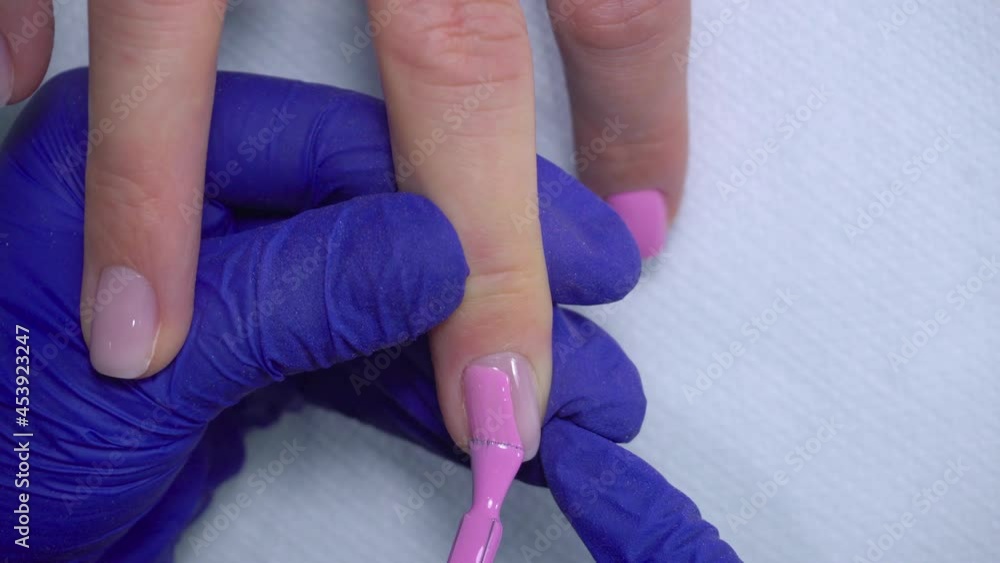 Manicure nail paint. Master applies gel polish on nails in manicure salon. Nail polish.