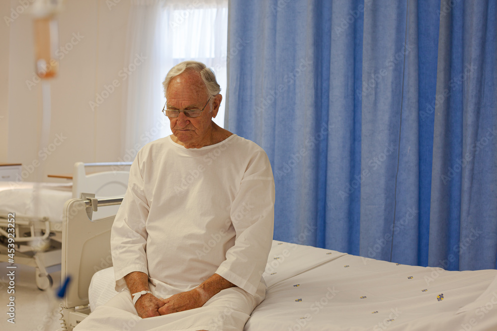 Older patient wearing gown in hospital room Older patient wearing gown in hospital room