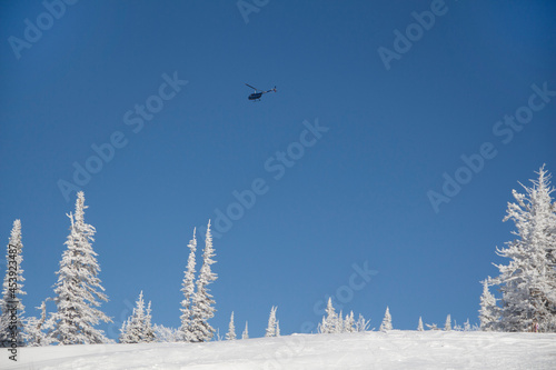 A helicopter over a snowy plain. Snow and blue sky. photo