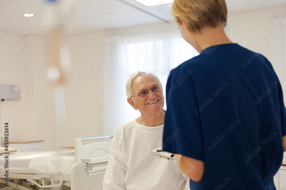 Nurse and older patient talking in hospital room Nurse and older patient talking in hospital room