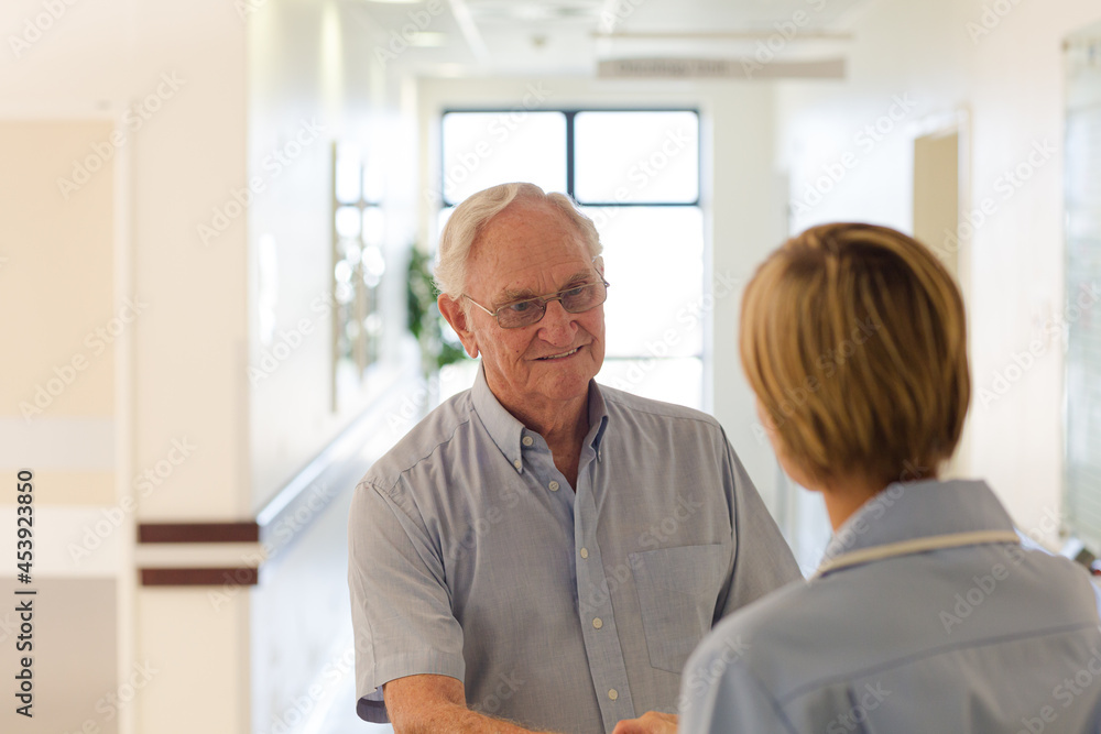 Obraz premium Older patient and nurse shaking hands in hospital