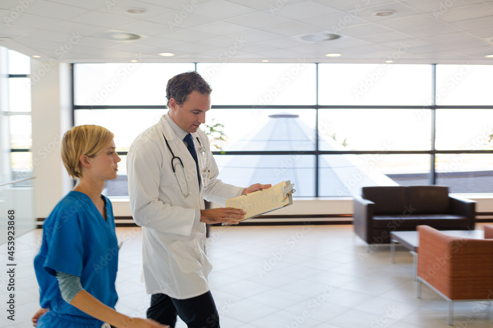 Fototapeta premium Doctor and nurse talking in hospital hallway