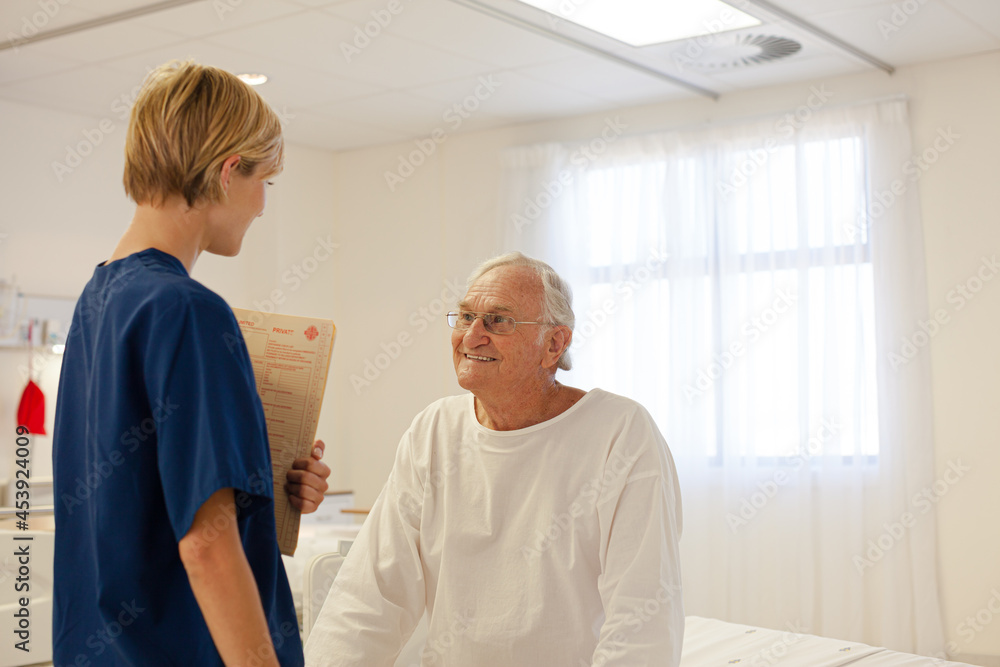 Obraz premium Nurse talking with older patient in hospital