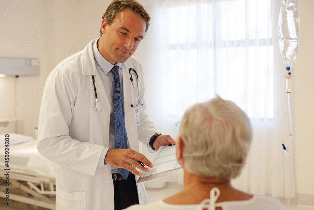 Fototapeta premium Doctor talking with patient in hospital room