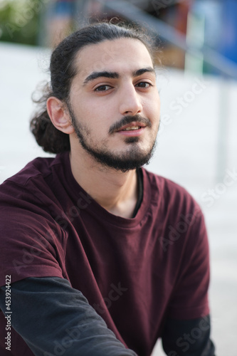 Close up portrait of handsome Arab man walking in the park