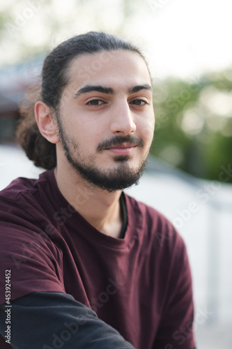 Close up portrait of handsome Arab man walking in the park