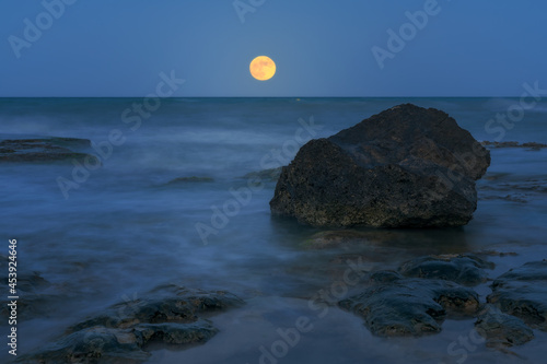 Fine art image of a rock and the full moon in Cervera Cape in Torrevieja photo