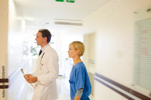 Fototapeta Naklejka Na Ścianę i Meble -  Nurse and doctor walking in hospital hallway