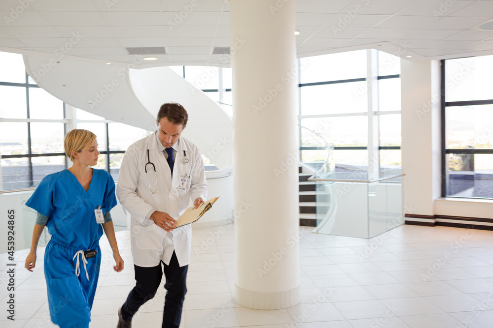 Doctor and nurse talking in hospital hallway Doctor and nurse talking in hospital hallway