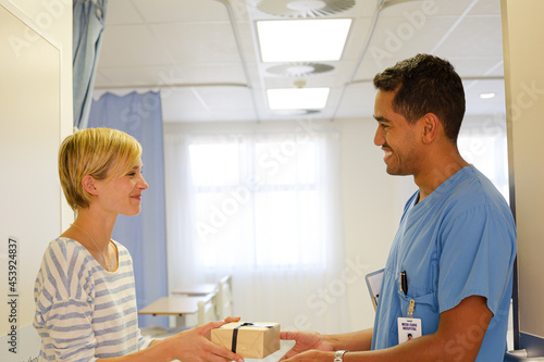 Patient giving nurse gift in hospital