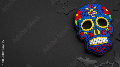 Obraz na płótnie Halloween backgrounds, Mexican culture and Dia de los Muertos (day of the dead) concept with colorful skull and black confetti isolated on dark background with copy space w salonie