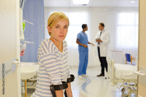 Patient using crutches in hospital room