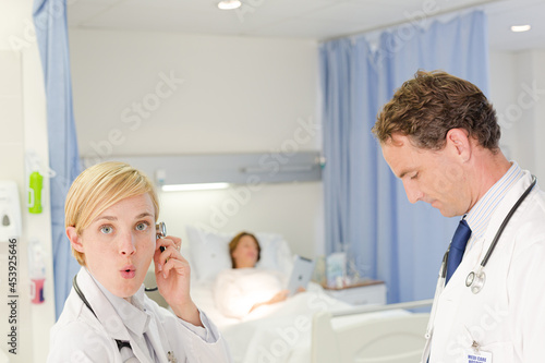 Doctor and nurse smiling in hospital room