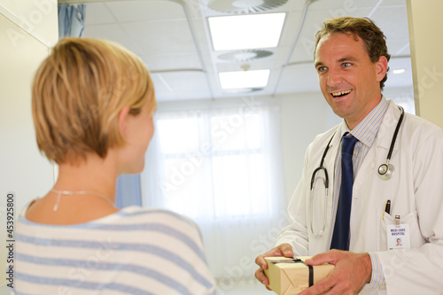 Patient giving doctor gift in hospital