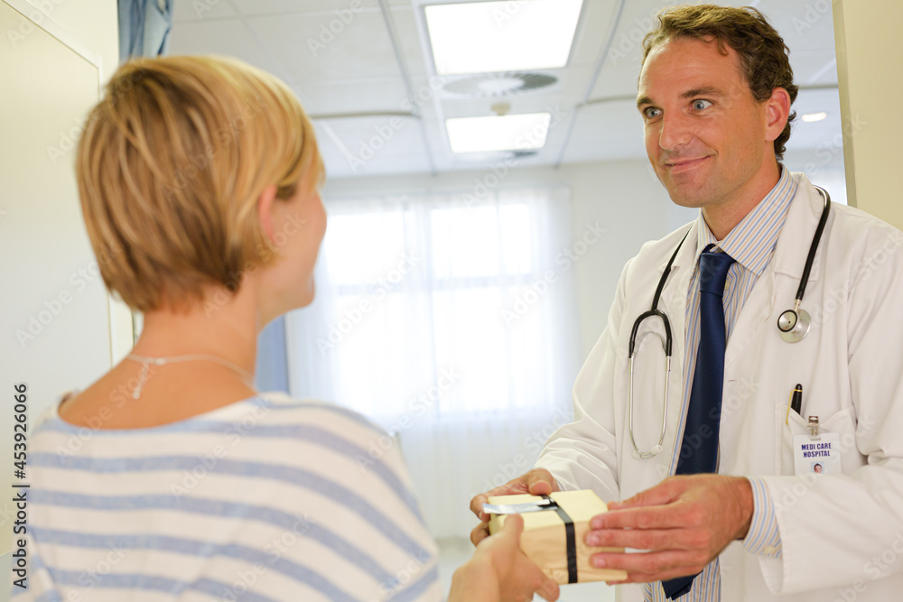 Obraz premium Patient giving doctor gift in hospital