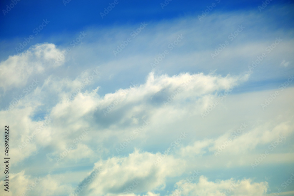 Blue sky background with blurred soft clouds