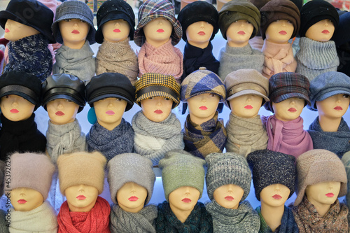 Winter and autumnal warm hats on mannequins in a shop window
