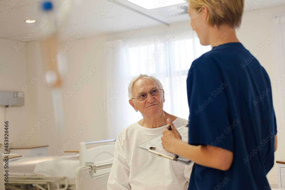 Obraz premium Nurse and older patient talking in hospital room