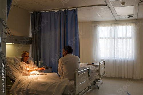 Doctor talking with patient in hospital room