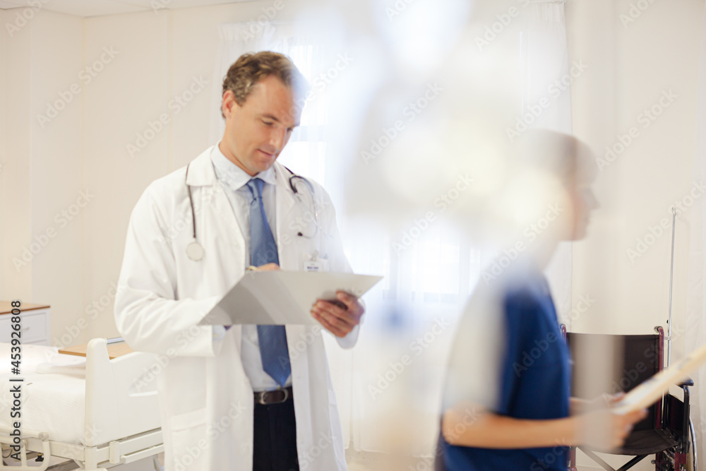Doctor and nurse talking in hospital room Doctor and nurse talking in hospital room