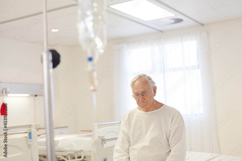 Older patient wearing gown in hospital room Older patient wearing gown in hospital room