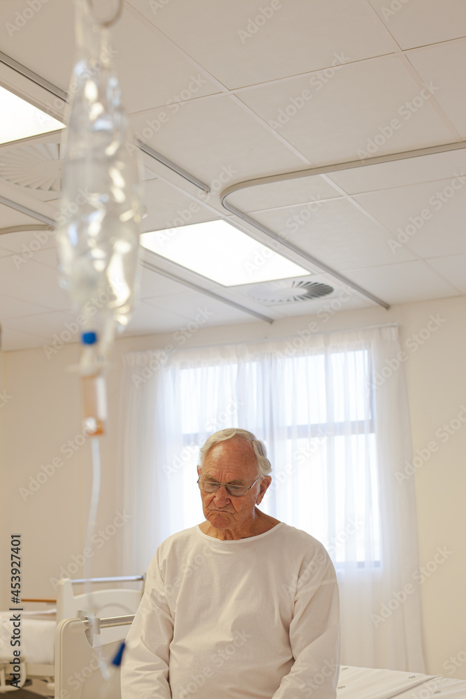 Fototapeta premium Older patient wearing gown in hospital room