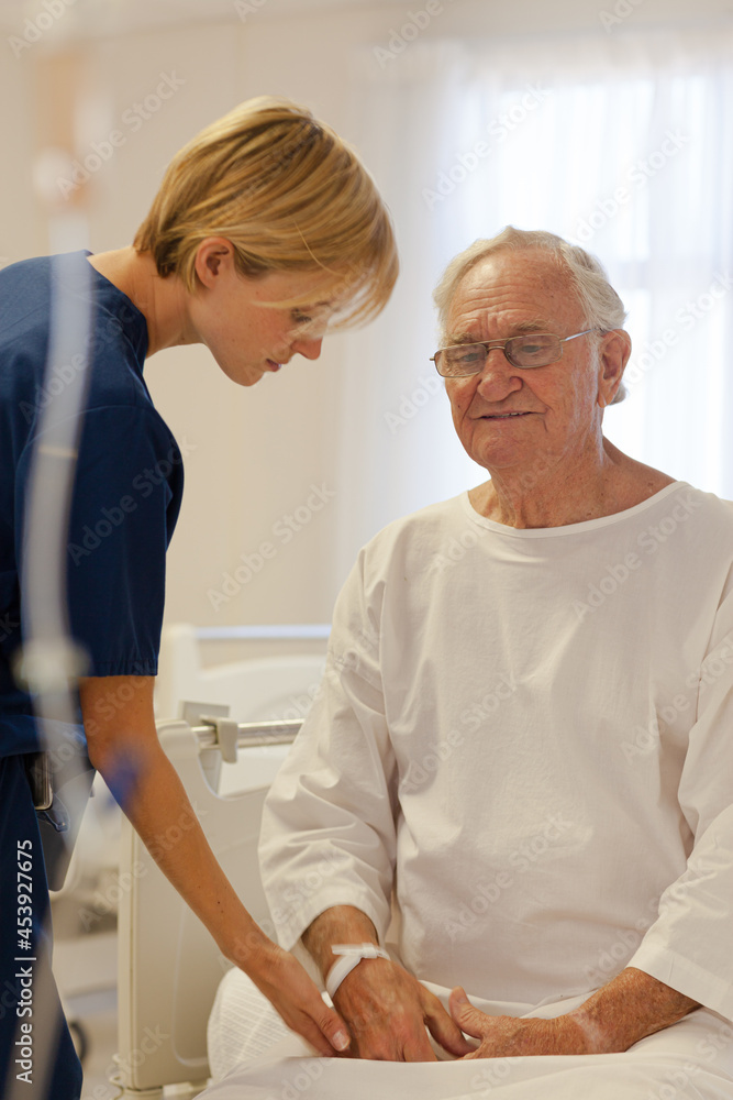 Fototapeta premium Nurse reading older patient's medical bracelet in hospital
