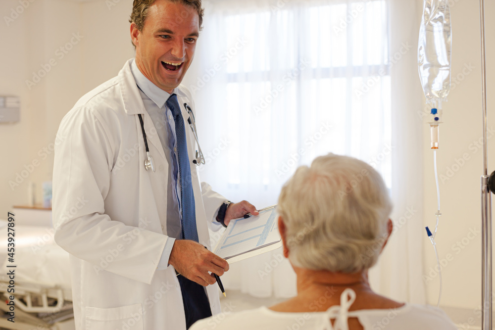 Doctor talking with patient in hospital room Doctor talking with patient in hospital room