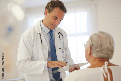 Doctor talking to older patient in hospital