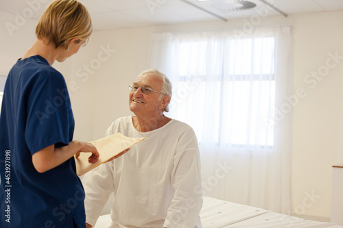 Nurse talking with older patient in hospital