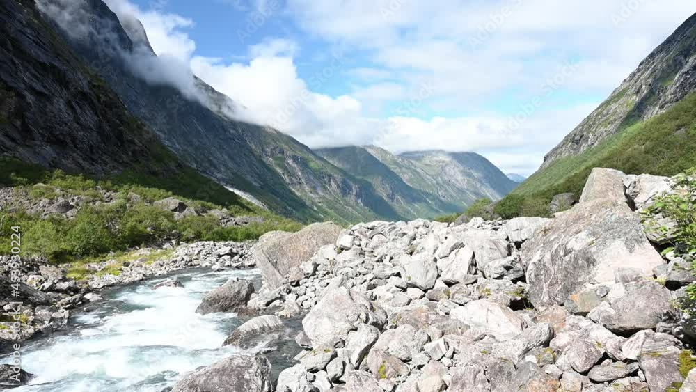 Beautiful scenery of a mountain river leading through the forested valley near Trollstigen, Norway. Beautiful scenery of a mountain river leading through the forested valley near Trollstigen, Norway.
