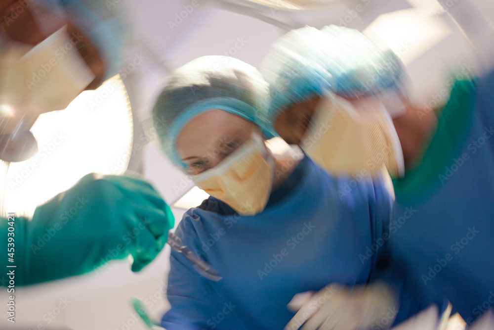 Surgeons bent over patient on operating table Surgeons bent over patient on operating table